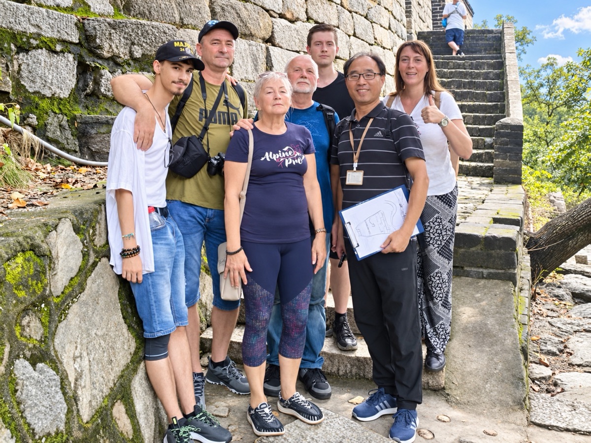 A tour group with their driver on the stone steps of the Great Wall